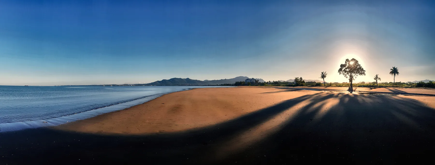 Wailoaloa Beach at Nadi, Fiji, looking along the sand towards the mountains
